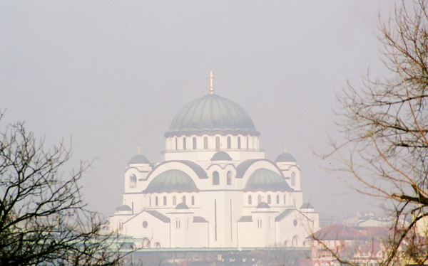 The massive yet airy bulk of Sveti Sava church dominates the
Belgrade skyline. It balances the bulk of the great mosques
of its time with lighter italianate influences reminiscent of
the Duomo in Florence.
This view, through the ever-present haze of urban smog,
enhances its feeling of lightness.
