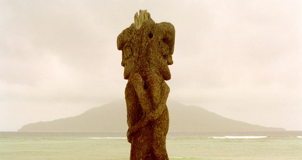This kind of carving is said to have originated on the 
island of Ambrym. This particular example is located outside
a hot spring and spa in North Efate island. The island in the
background is Emau, part of the Shepherd Islands group.

