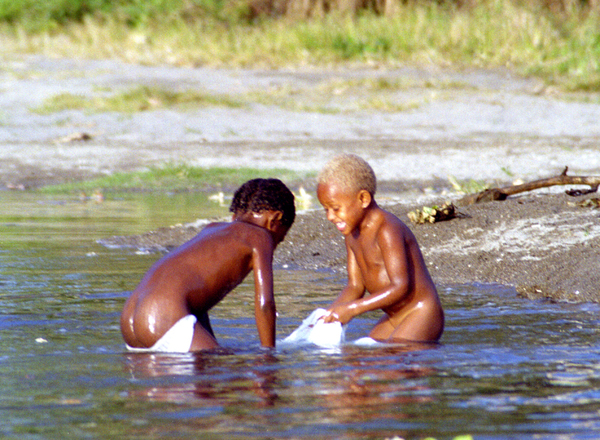Two children play in a tidal pool by filling a plastic 
shopping bag with water.
Black Sand is little known and rarely visited by tourists
and expats, as it is situated near one of the poorest
neighbourhoods in Port Vila.

