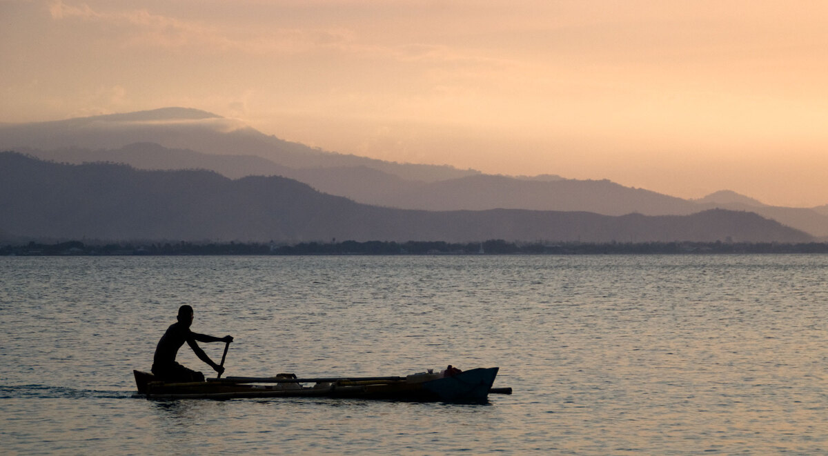 Sunsets in Dili during the dry season are routinely spectacular. Here, a young man ferries water back to his family.
