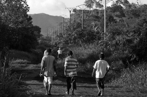Three youths wander down one of the thoroughfares in Port Vila's Freswota neighbourhood.
