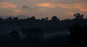 Smoke drifts over the nearby hills as the sun sets on the Freswota neighbourhood in Port Vila.
