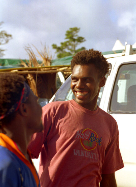 
Kiwanis Race day is a huge event in Port Vila. Nearly a third of the
population gathers on the Elluk heights overlooking Port Vila harbour
to watch the finest horses in the nation show their mettle. 
Two young men joke around in the parking lot outside the track. The shirt, by the way, is hand-painted. There is no Hard Rock Caf&eacute; in Vanuatu.

