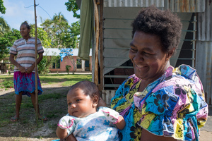 Wilma's grandmother holds Francois, born just a month after cyclone Pam. Wilma stands in the background.
