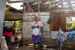 Wilma holds her baby, Francois, in the middle of their family home on Ifira island. It is still in need of major renovations three months after cyclone Pam caused extensive damage.
