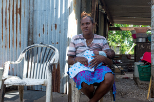 Wilma nurses her baby, Francois, in the middle of their family home on Ifira island. It is still in need of major renovations three months after cyclone Pam caused extensive damage.
