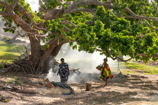 Two women burn off underbrush at the shore of Ifira island. Even three months after cyclone Pam, large piles of windfallen wood and debris still remain.
