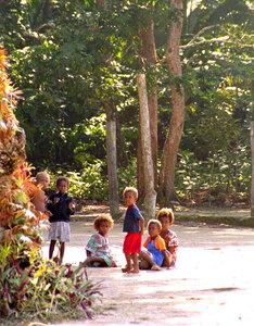 On our first full day on the island of Vanua Lava, we walked across it to the
small village of Mosinet. The entire population, about 50 people, was gathered
under a large mango tree.
When they first saw me coming, most of the children ran away in fear. 
Their curiousity eventually got the better of them, and by the time I was
a safe fifty yards away, they began to emerge - speculating, I don't
doubt on what kind of strange beast is a white man.
I wish them luck with that.
