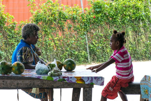 Grandmother and granddaughter confer at Santo Market.
