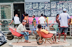 Men and boys resting in their wheelbarrows, waiting to be paid to haul goods around the town centre is a common sight in Suva.
