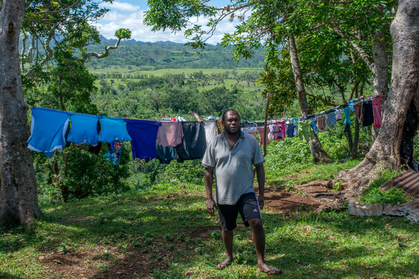 Rachel's father stands in their yard, watching work progress.
