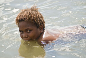 A young boy swimming at Blacksand beach in Port Vila.
