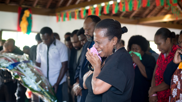 A woman weeps as she accompanies the Prime Minister (background) to pay their respects to President Baldwin Lonsdale, whose body lies in state at the State House Nakamal.
