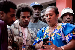 Digicel's Maureen George demonstrates GPRS to onlookers.