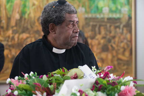 A clergyman, red-eyed, waits to pay his respects to Edward Natapei, whose body lies in state at Parliament.
