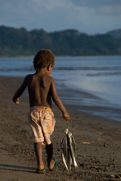 A young boy carries the day's catch home along Blacksand beach.
