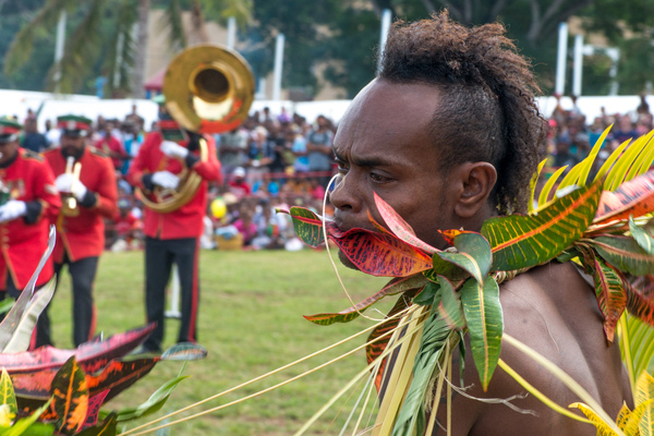A kastom dancer from Mere Lava performs while the VMF band plays in the background.
