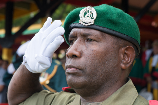 An officer salutes while the national anthem is played.
