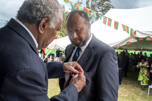 Prime Minister Charlot Salwai receives a distinguished service medal from President Baldwin Lonsdale.
