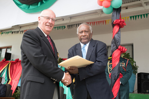 A meritorious service medal recipient shakes hand with President Lonsdale.
