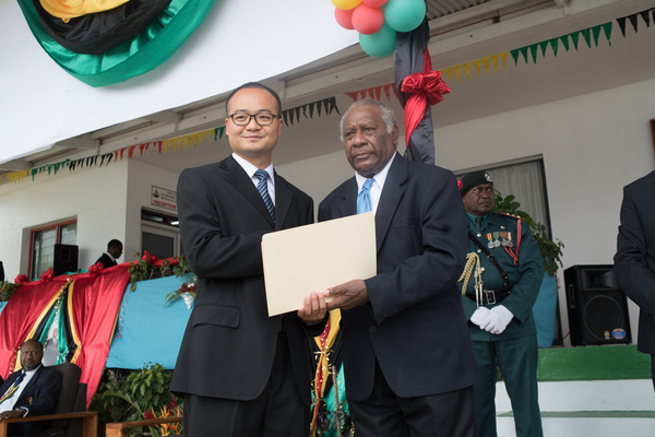 Mr San Yong receives a meritorious service medal from President Baldwin Lonsdale.
