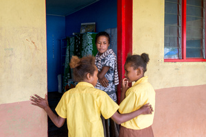 Children from St Joseph school near Port Vila enter the classroom as their teacher looks on.
