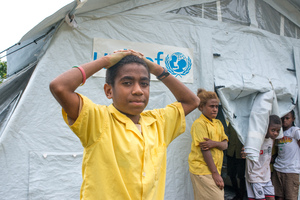 A student from St Joseph school near Port Vila stand outside the tent that has been his classroom since cyclone Pam destroyed part of the school. If not for the shelter supplied by UNICEF, students would have been sent home on a rotating basis.
