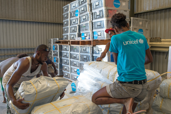 Staff and volunteers wrangle over 90 tonnes of newly arrived emergency supplies at the UNICEF warehouse near Port Vila, Vanuatu. The influx of supplies required the construction of a new temporary storage facility as well.
