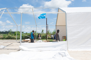 Staff and volunteers wrangle over 90 tonnes of newly arrived emergency supplies at the UNICEF warehouse near Port Vila, Vanuatu. The influx of supplies required the construction of a new temporary storage facility as well.
