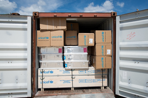 Staff and volunteers wrangle over 90 tonnes of newly arrived emergency supplies at the UNICEF warehouse near Port Vila, Vanuatu. The influx of supplies required the construction of a new temporary storage facility as well.
