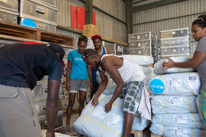 Staff and volunteers wrangle over 90 tonnes of newly arrived emergency supplies at the UNICEF warehouse near Port Vila, Vanuatu. The influx of supplies required the construction of a new temporary storage facility as well.
